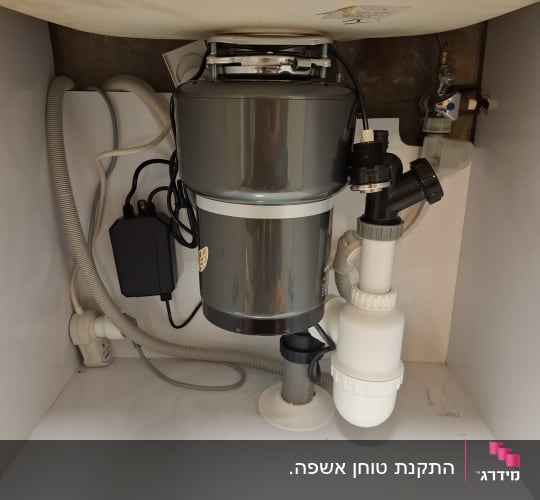 מתקן טוחן אשפה מתחת לכיור עם צינורות וחיבורים